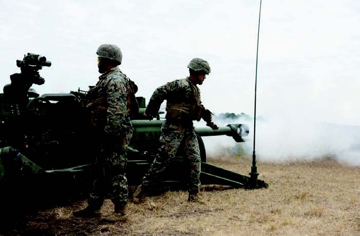 Cpl Erick Leon, right, a Queens, NY, native and a field artillery cannoneer with 1/10 Mar, fires an M777 towed 155 mm howitzer during field training on Camp Lejeune, NC. (Photo by LCpl Jonathan Rodriguez Pastrana.)